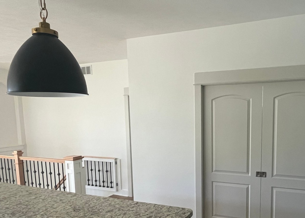 An interior shot of a residential renovation jobsite where the hardwood floors have been carefully covered and protected with Ram Board and orange tape before painting or construction begins.
